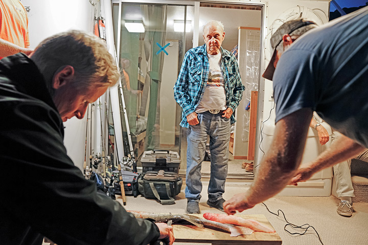 Gene observes younger men clean the day’s catch.